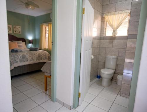 a bathroom with a bed and a toilet in a room at St Lucia Heights in St Lucia