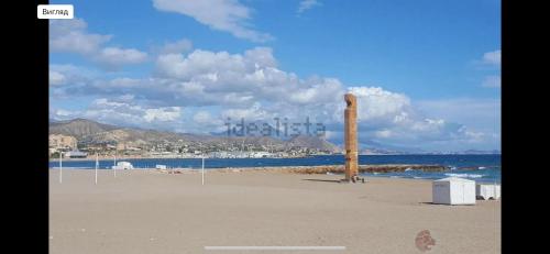 a beach with a wooden pole in the sand at 5 minutos hacia el mar in El Campello