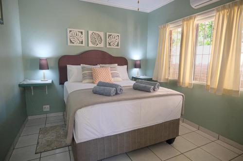 a bedroom with a large bed and two windows at St Lucia Heights in St Lucia