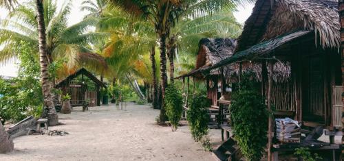 a group of palm trees next to a building at manyaifun guest house in Minyaifuin