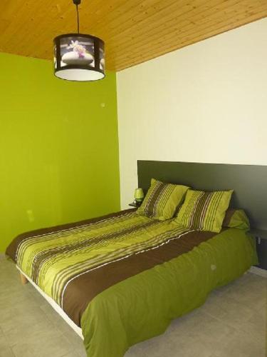 - une chambre verte dotée d'un lit avec un mur vert dans l'établissement maison les lilas, à La Trivale