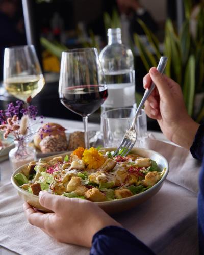 a person eating a bowl of salad with a glass of wine at Apollo Boutique Hotel in Rome