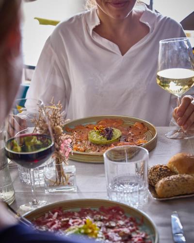 a woman sitting at a table with a plate of food and wine at Apollo Boutique Hotel in Rome