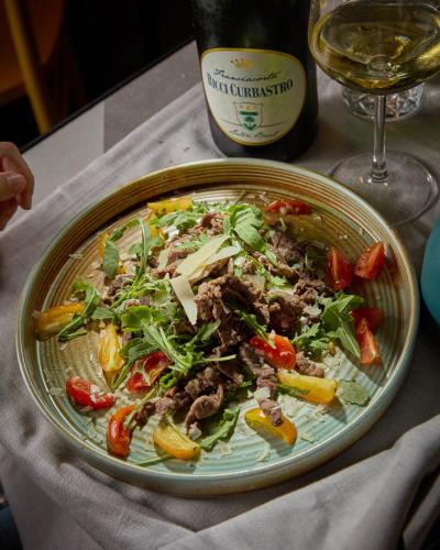 a plate of food on a table next to a bottle of wine at Apollo Boutique Hotel in Rome