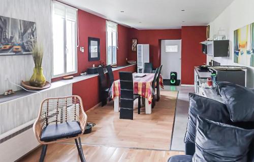 une cuisine avec des murs rouges et une table et des chaises dans l'établissement Beautiful Apartment In Saint-Evarzec, à Saint-Évarzec
