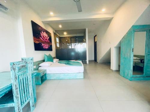 a bedroom with a bed and a painting on the wall at Villa LA Kurumba in Ambalangoda