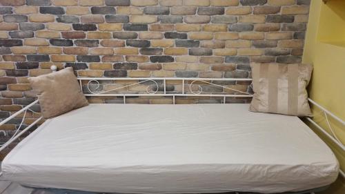 - un lit dans une chambre à côté d'un mur en briques dans l'établissement Ready Appartement proche aéroport Orly, à Athis-Mons