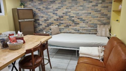 Cette chambre comprend un lit, une table et un canapé. dans l'établissement Ready Appartement proche aéroport Orly, à Athis-Mons