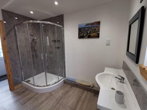 a bathroom with a shower and a toilet and a sink at Skye Stays in Staffin