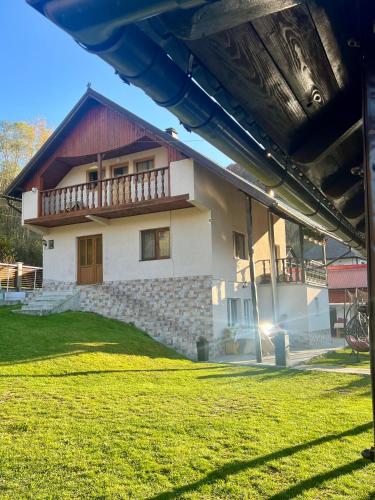 a house with a grass yard in front of it at Cabana Baraj Apuseni Mountains in Mihoeşti