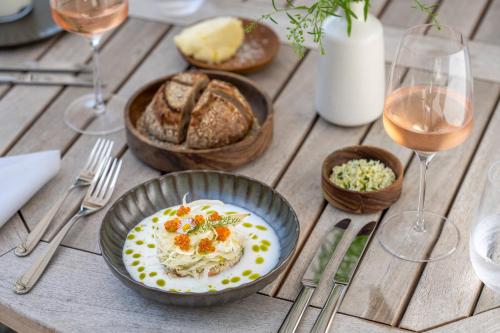 a table with a plate of food and glasses of wine at Seegut Zeppelin in Friedrichshafen
