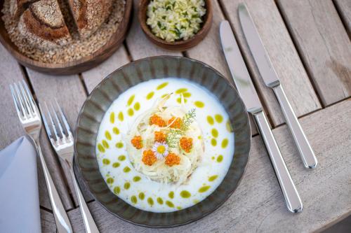 a bowl of rice with carrots on a table with silverware at Seegut Zeppelin in Friedrichshafen