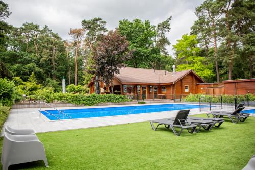 a house with a swimming pool in a yard at StayatSas Tiny House Pippa in de bossen op de Veluwe in Doornspijk
