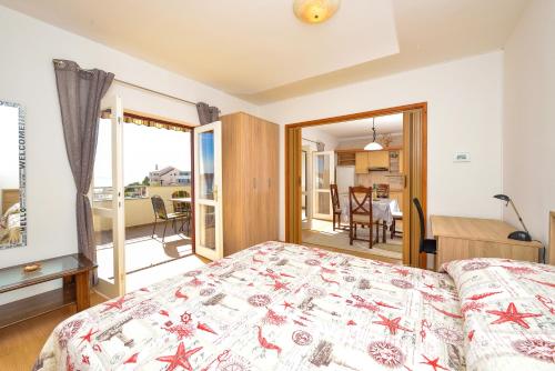 a bedroom with a bed and a balcony at Apartman Ivka A1 in Petrcane
