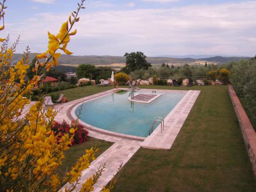 a swimming pool in the garden of a house at Agriturismo Borghetto Il Montino in Rapolano Terme