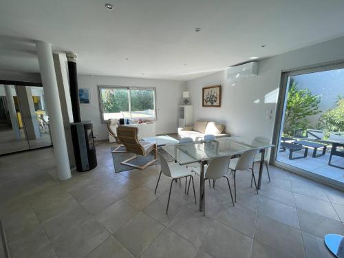 - une salle à manger et un salon avec une table et des chaises en verre dans l'établissement Sète, Villa 4 étoiles avec piscine à deux pas de la plage !, à Sète
