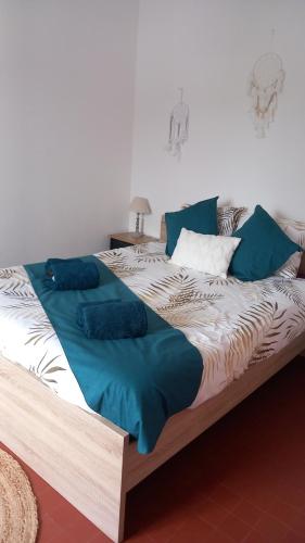 Elle comprend un grand lit avec des draps et des oreillers bleus. dans l'établissement Gîte Au Gré du Canal ZOO Beauval 4 personnes parking, à Selles-sur-Cher
