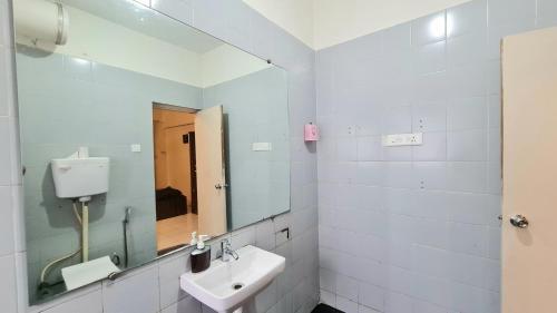 a white bathroom with a sink and a mirror at Rostel Backpackers Hostel in Pune