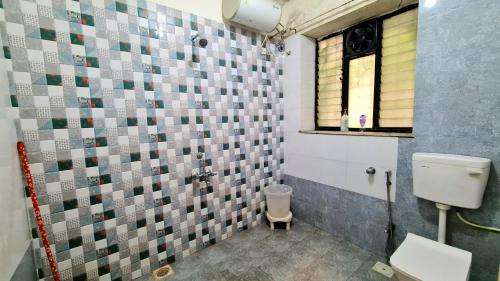 a bathroom with a toilet and a window at Rostel Backpackers Hostel in Pune
