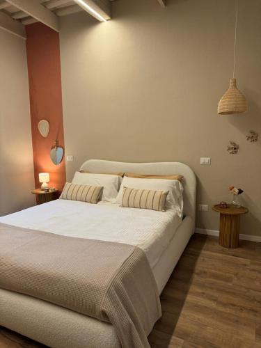 a bedroom with a large white bed with two pillows at Dimora Alberto in Lucca