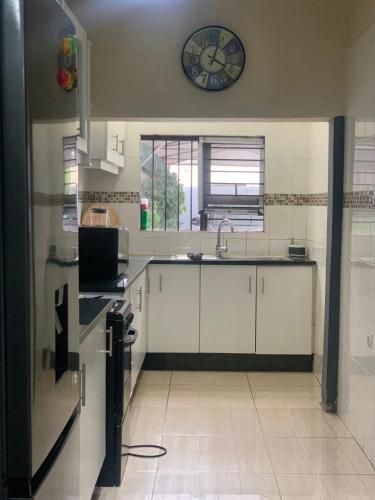 a kitchen with a sink and a clock on the wall at Bianca's in Matola