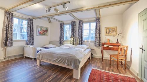 1 Schlafzimmer mit 2 Betten und einem Schreibtisch in der Unterkunft Klosterkrug Apartments in Lüneburg