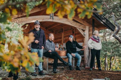 a group of people standing in front of a cabin at Hällesdalens Gård - semesterhus i Bohuslän in Svenshögen