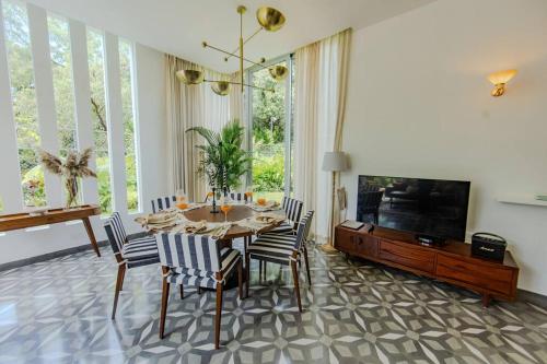 a dining room with a table and chairs and a television at Presidential Luxury Villa Anjuna with Private Pool and Dedicated Caretaker in Old Goa