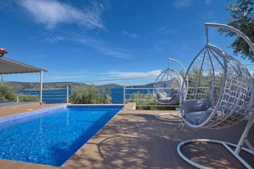 a swinging chair next to a swimming pool at Marea Alonissos in Alonnisos Old Town