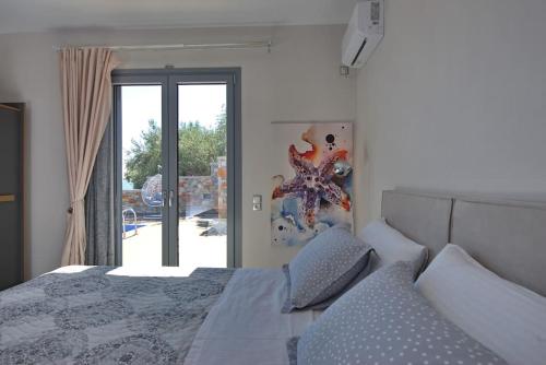 a bedroom with a bed and a sliding glass door at Marea Alonissos in Alonnisos Old Town
