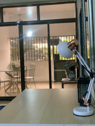a desk with a lamp and a table in a room at Bianca's in Matola