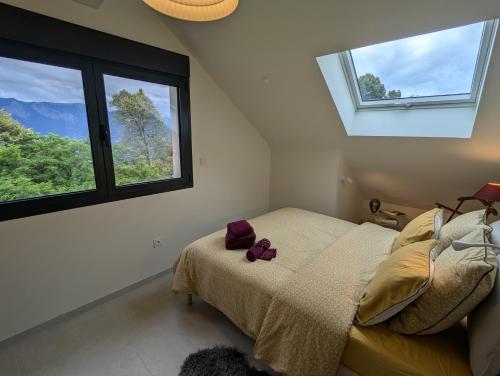 une chambre avec un lit et deux fenêtres dans l'établissement Gîte de Charme de Combeloup, à Murianette