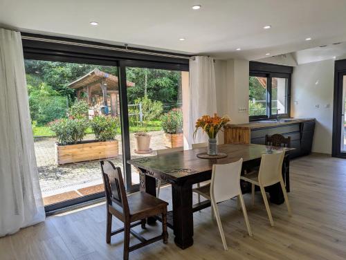 une cuisine et une salle à manger avec une table et des chaises dans l'établissement Gîte de Charme de Combeloup, à Murianette