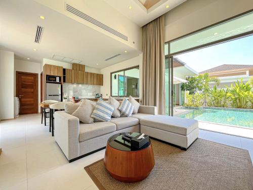 a living room with a couch and a table at SHAMBHALA GRAND Pool Villas x MonthStayZ Thailand in Phuket