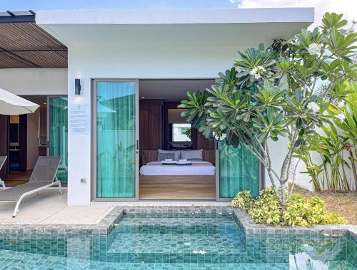 a villa with a swimming pool and a bedroom at SHAMBHALA GRAND Pool Villas x MonthStayZ Thailand in Phuket