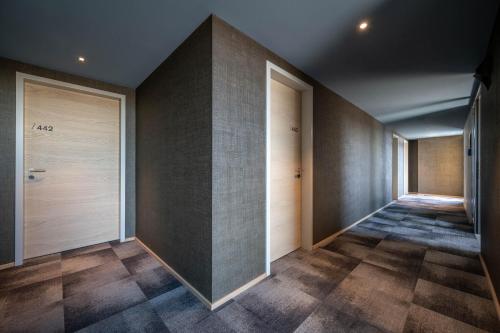 a hallway with wooden doors and tile floors at Hotel Maier in Friedrichshafen