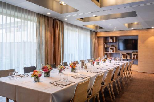 a conference room with a long table with chairs and flowers at Hotel Maier in Friedrichshafen