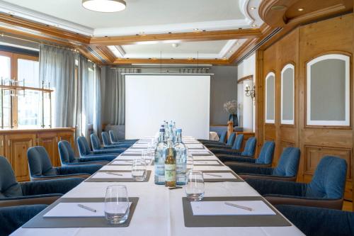 a conference room with a long table and blue chairs at Hotel Maier in Friedrichshafen