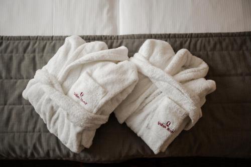 a pair of white towels on a bed at Qubus Hotel Głogów in Głogów