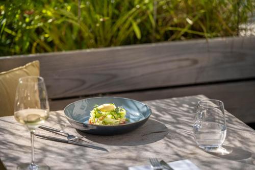 a bowl of salad on a table with wine glasses at Hotel Maier in Friedrichshafen