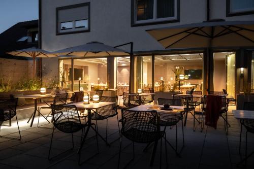 a patio with tables and chairs and umbrellas at Hotel Maier in Friedrichshafen