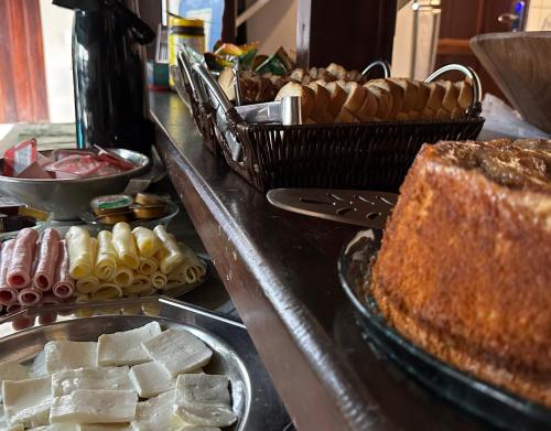 a buffet line with different types of bread and pastries at Pousada Villa Aman in Paraty
