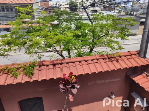 a red tile roof with flowers on top of a building at Mi Casa Rio Garagem Wi-Fi Grátis Próximo Praia Barra in Rio de Janeiro