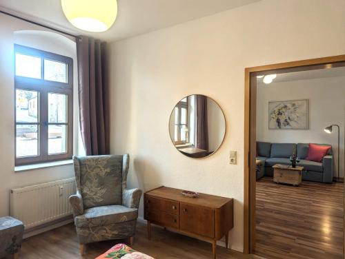 a living room with a chair and a mirror at Vintage-Wohnung Silberstadt in Freiberg