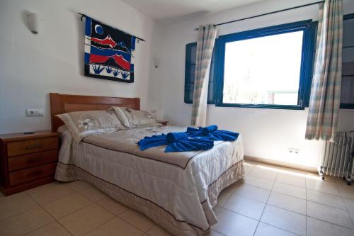a bedroom with a bed with a blue bow on it at Casa Palmeras, Punta Limones, Playa Blanca, Lanzarote in Playa Blanca
