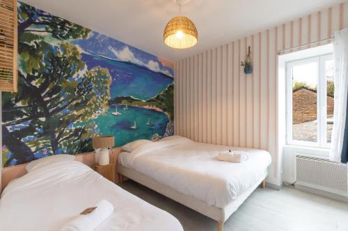 Dos camas en una habitación con un cuadro en la pared. en Cabana & On dirait le Sud, en Flacé-lès-Mâcon