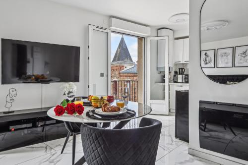 une salle à manger avec une table sur laquelle se trouve de la nourriture dans l'établissement Studio avec jacuzzi & vue sur le parc Soubiran, à Dammarie-les-Lys