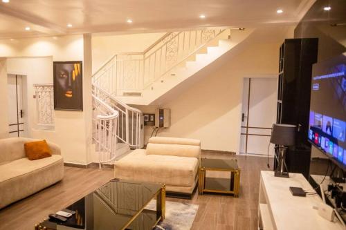 a living room with a couch and a tv at West End Mansion in Ikota