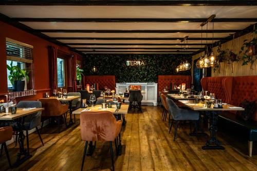 a restaurant with tables and chairs in a room at Tottington Manor Hotel in Henfield