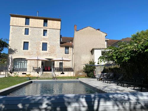 a house with a swimming pool in front of a building at La Bellours Chambre D'Hôtes in Cahors